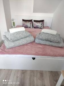 a bed with three pillows on top of it at Apartament Kapitańska in Niechorze
