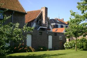 una casa con porte bianche e tetti rossi di Miniloft Abel Abri a Zingem