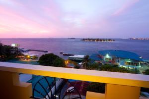 een balkon met uitzicht op de oceaan in de nacht bij Mookai Hotel in Male City