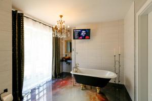 W łazience z żyrandolem znajduje się wanna. w obiekcie Iseroase House Deluxe w mieście Pobiedna
