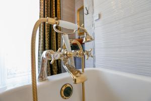 W łazience znajduje się wanna z prysznicem. w obiekcie Iseroase House Deluxe w mieście Pobiedna +20 zdjęć