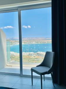 a chair sitting in front of a large window at Hotel VIU57 in Mellieħa