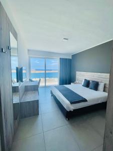 a bedroom with a bed and a view of the ocean at Hotel VIU57 in Mellieħa
