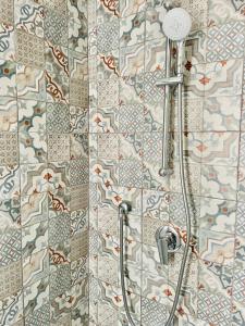 a shower in a bathroom with a tiled wall at Hotel VIU57 in Mellieħa