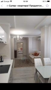 uma cozinha e sala de estar com um sofá e uma mesa em HPC Luxury Apartaments em Tiraspol