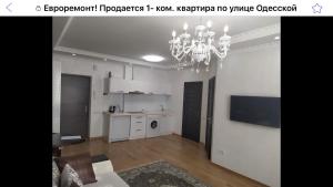 a living room with a chandelier and a kitchen at HPC Luxury Apartaments in Tiraspol