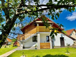 a house with wooden accents on the side of it at Studio Apartmani Patricia in Smoljanac