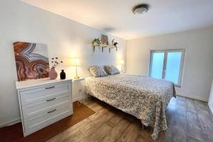a bedroom with a bed and a dresser and a window at Au coeur de la ville in Spa