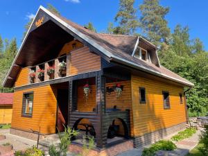 a wooden house with a porch and flowers on it at Grisli house in Gauja