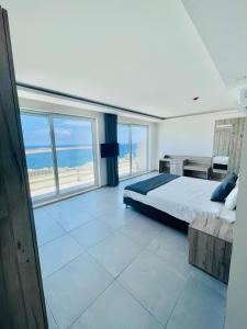 a bedroom with a bed and a view of the ocean at Hotel VIU57 in Mellieħa