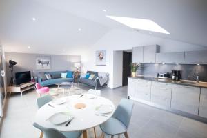 a kitchen and living room with a white table and chairs at Appartement Mont Blanc - Vue Lac in Sévrier