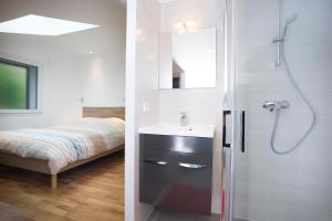 a bathroom with a sink and a shower and a bed at Appartement Mont Blanc - Vue Lac in Sévrier