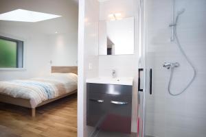 Un baño con lavabo y ducha y una cama. en Appartement Mont Blanc - Vue Lac, en Sévrier