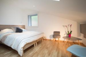 a bedroom with a bed and a table and a chair at Appartement Mont Blanc - Vue Lac in Sévrier