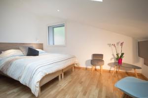 Un dormitorio con una cama, una mesa y una silla. en Appartement Mont Blanc - Vue Lac, en Sévrier