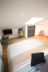 Un dormitorio con una gran cama blanca en una habitación. en Appartement Mont Blanc - Vue Lac, en Sévrier