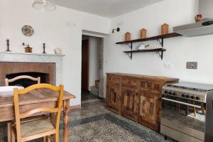 La cocina está equipada con fogones, mesa de madera y encimera. en Cà del Nonno, en Fivizzano