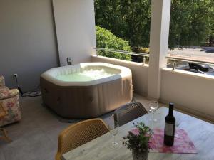 a bath tub sitting on a patio with a table and wine glasses at Apartments Ante in Omiš