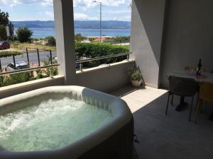 a bath tub in a balcony with a view of the ocean at Apartments Ante in Omiš