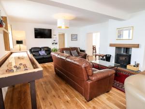 a living room with a leather couch and a fireplace at The Bull Inn in Caernarfon