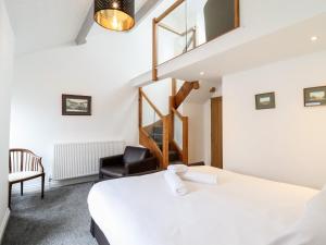 a room with a bed and a chair and a staircase at The Bull Inn in Caernarfon
