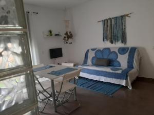 ein Wohnzimmer mit einem Bett und einem Tisch in der Unterkunft Gran terraza con piscina in Sant Jaume d’Enveja