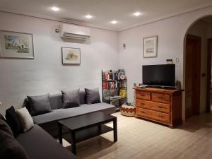 - un salon avec un canapé et une télévision dans l'établissement Casa Margarete Puerto de Mazarron, à Puerto de Mazarrón