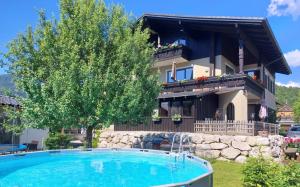 a villa with a swimming pool in front of a house at Apartmenthaus Hinterer in Bad Goisern