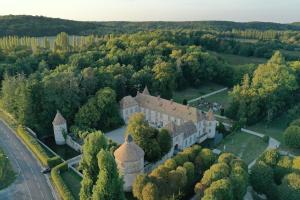 una vista aerea di un castello alberato e di una strada di Château de la Cour Senlisse a Senlisse