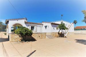 uma casa branca com um arco e árvores em frente em villa mimoses em Plamanyola