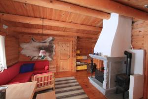 uma sala de estar com um sofá vermelho e uma lareira em Lusæter Timber Cabins em Heidal