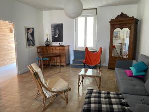 ein Wohnzimmer mit einem Sofa und einem Tisch in der Unterkunft Maison de famille aux Sables d'Olonne in Les Sables-dʼOlonne