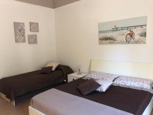 a bedroom with two beds and a picture on the wall at La Casa Sulla Scogliera in Cefalù
