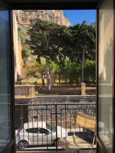 a balcony with a view of a car and a mountain at La Casa Sulla Scogliera in Cefalù