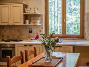 eine Blumenvase auf einem Tisch in einer Küche in der Unterkunft Podere Mocai - Cottage nel bosco in Montieri