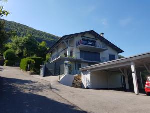 una casa con un coche aparcado delante de ella en Appartement Semnoz - Vue Lac, en Sévrier