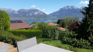 een uitzicht op een meer en de bergen vanuit een huis bij Appartement Semnoz - Vue Lac in Sévrier
