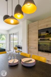 d'une salle à manger avec une table en bois et des lumières jaunes. dans l'établissement L'appartement JARDIN avec vue montagnes, à Sévrier