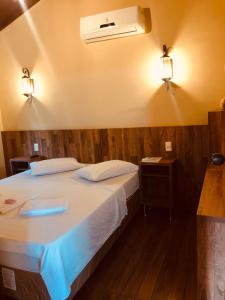 a bedroom with a bed with a air conditioner on the wall at Pousada Villa da Serra in Brumadinho