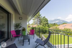 een balkon met stoelen en uitzicht op de bergen bij Appartement Lac in Sévrier