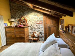 a bedroom with two beds and a stone wall at Maison Fort Bovet #Bluchalet in La Salle
