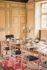 Château de la Cour Senlisse في Senlisse: غرفة طعام مع طاولة وكراسي خشبية كبيرة