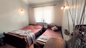 una camera da letto con due letti, un tavolo e una finestra di AGROTURYSTYKA U MADZI a Korbielów
