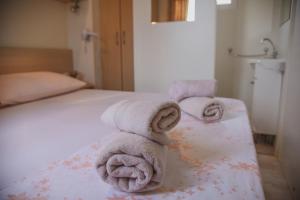 - une chambre avec un lit et des serviettes dans l'établissement Mobile Homes Bilice, à Bilice