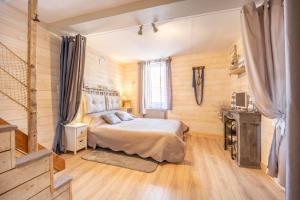 1 dormitorio con 1 cama en una habitación con paredes de madera en Le ptit passage en Saint-Aubin-sur-Mer