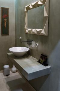 a bathroom with a sink and a mirror at Raffinato Suite (Cielo suites) in Kavála