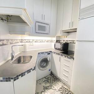 a kitchen with a sink and a washing machine at Stay Inn Madrid in Madrid