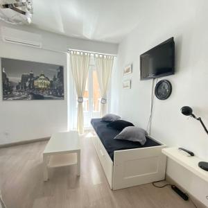 - une chambre avec un lit et une télévision murale dans l'établissement Stay Inn Madrid, à Madrid