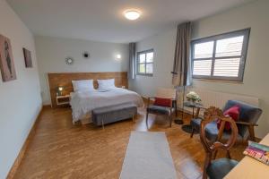 1 Schlafzimmer mit einem Bett, 2 Stühlen und einem Tisch in der Unterkunft Altstadthotel Eibsen in Otterndorf
