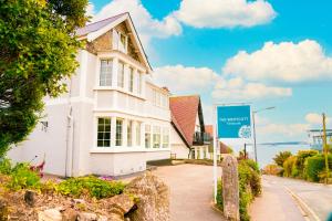 Biały dom z niebieskim znakiem przed nim w obiekcie The Westcott by the Sea - Just for Adults w mieście Falmouth